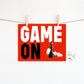 Block letters of Game On on blue or red background with king and queen game pieces for digital download. 
